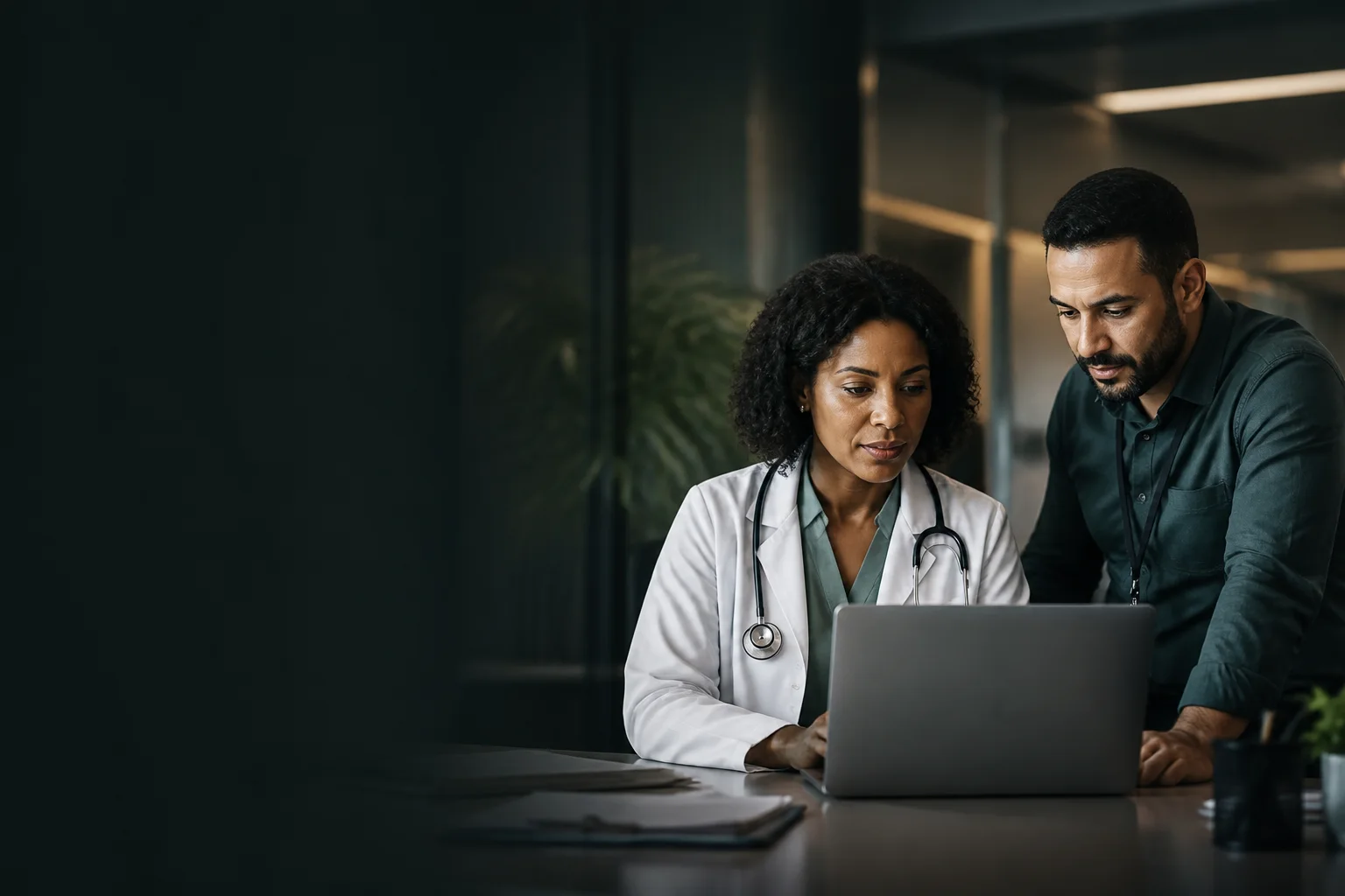 Médica e gestor de operação de saúde trabalhando em um sistema corporativo